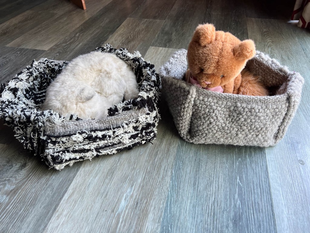 Handwoven wool cat beds with stuffed toy kitties inside.