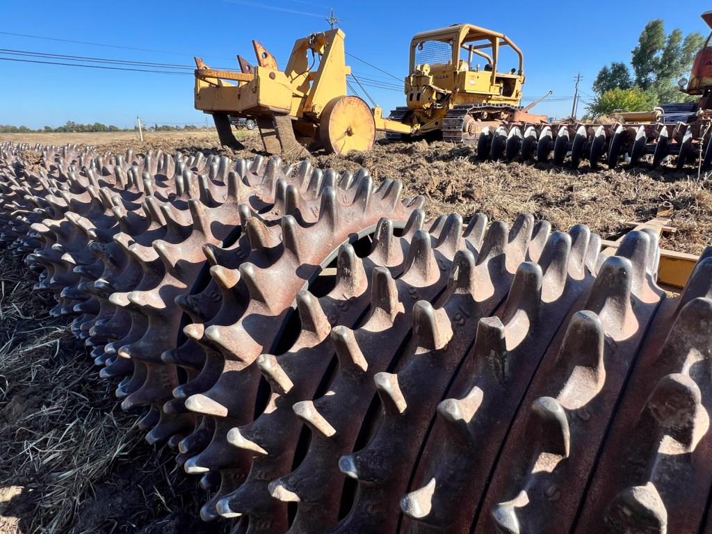 Close up view of ring rollers attached to disc behind a tractor.