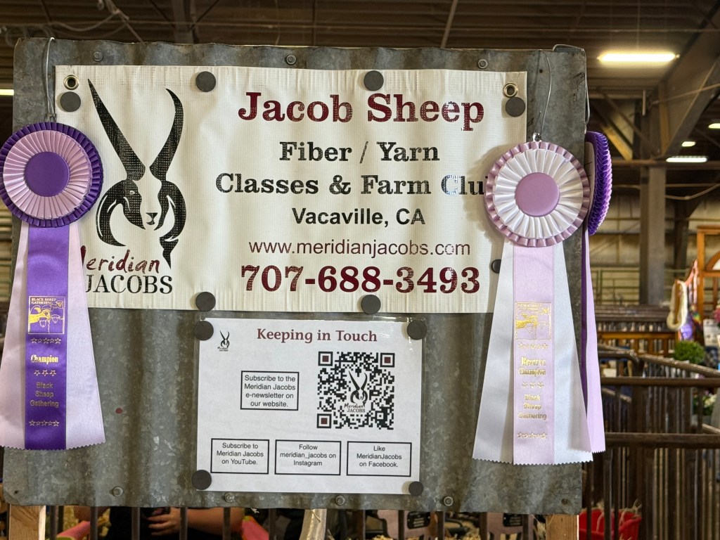 Sign about Meridian Jacobs with champion ribbons displayed.