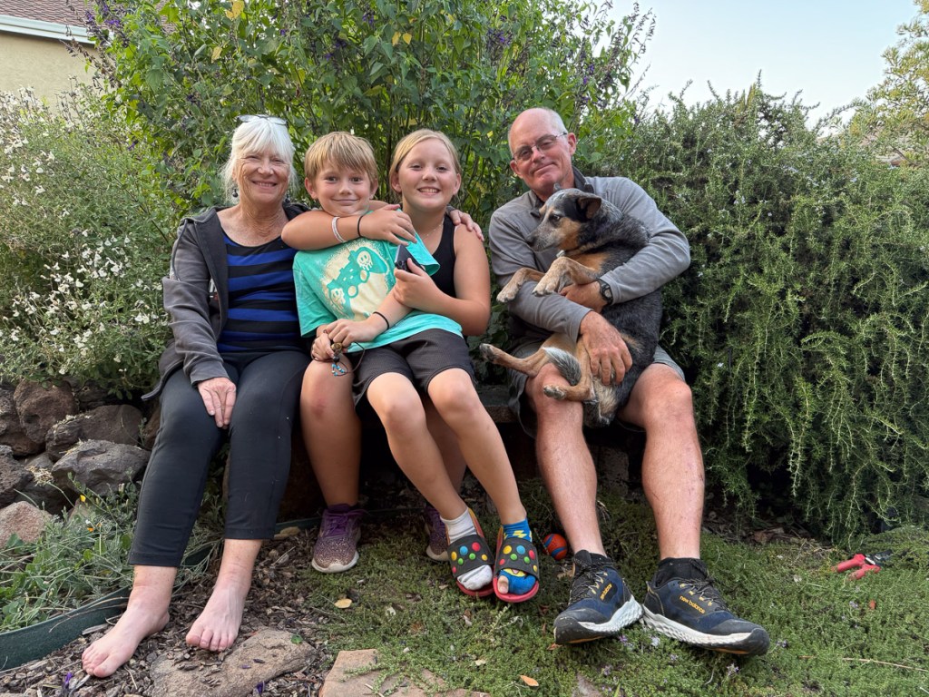 Family photo of two adults and two kids and a dog.