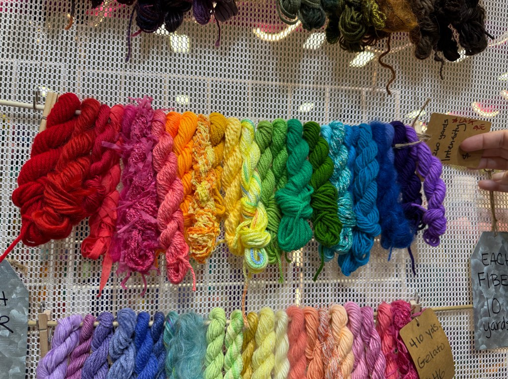 Array of small skeins of yarn arranged in rainbow color.