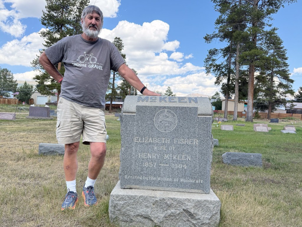 Dan standing next to a gravestone that says McKeen.