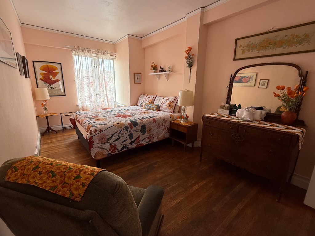 Bedroom with wood floor and poppy themed decor.