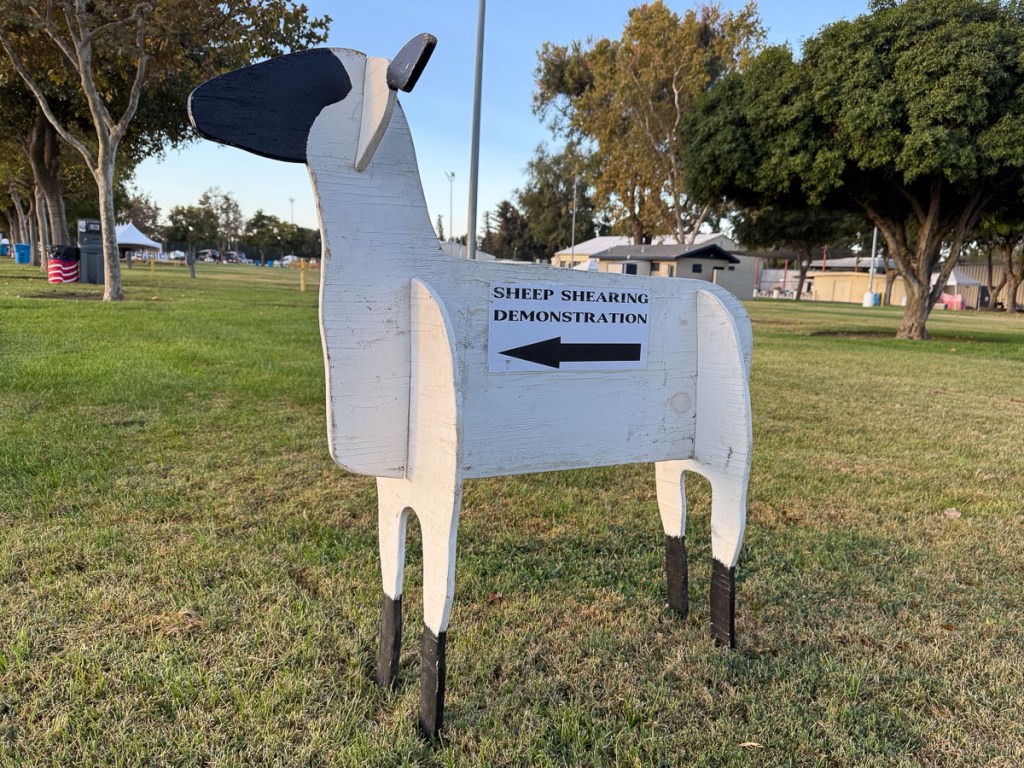 Wooden sheep with an arrow pointing to shearing demonstrations.